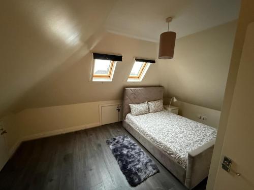 a small bedroom with a bed and two windows at Central London double bed apartment Free Parking Incl Stays upto 6 in London