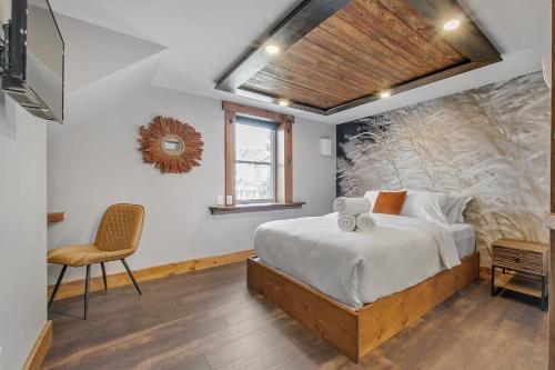 a bedroom with a large bed and a chair at auxportesdesMilleIles in Laval
