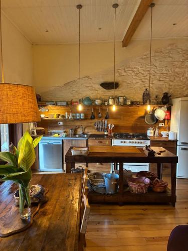 a large kitchen with a wooden table and a counter at Casas na montanha vistas fantásticas com piscina in Vinhais