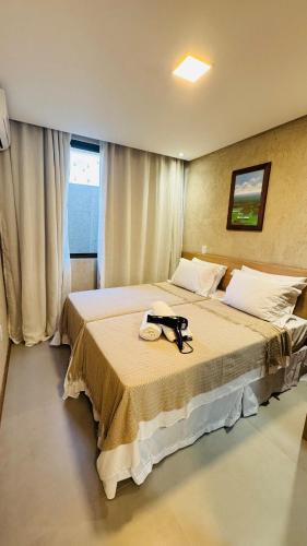 a hotel room with a bed with a hat on it at Sunset Villas Milagres - Casa Anahi in Passo de Camarajibe