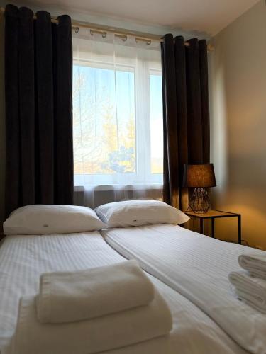 a bedroom with two beds and a large window at Apartament na Błoniach in Sanok