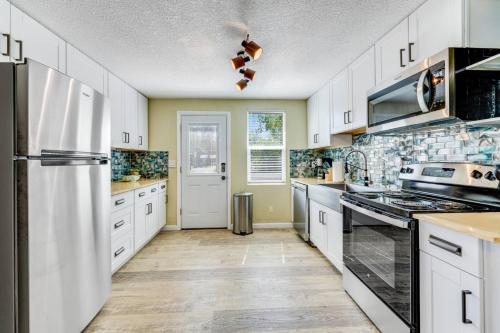 a kitchen with white cabinets and a refrigerator at Rosemont Cottage in Florence