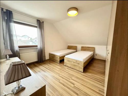 a small room with two beds and a window at YOLKI HAUS moderne Apartments, nahe Wölfersheimer See in Wölfersheim