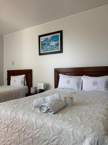 a bedroom with two beds with a towel on the bed at Hotel Luz de Luna in Atico