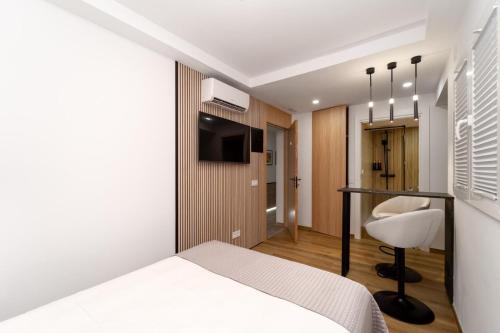 a bedroom with a bed and a desk and a chair at Boutique Centro Hostal in Alicante