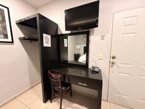 a black desk with a television on a wall at Hotel Los Diamantes in Rancho Los Limones