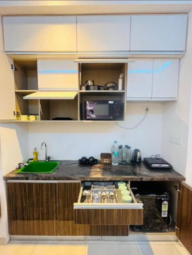 a kitchen with a counter with a sink and a microwave at Aawas studio in Noida