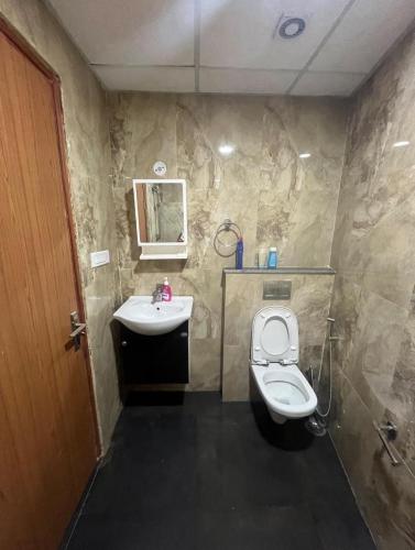 a bathroom with a toilet and a sink at Aawas studio in Noida