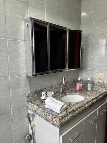 a bathroom counter with a sink and a mirror at Casa no Roteiro do Vinho in São Roque