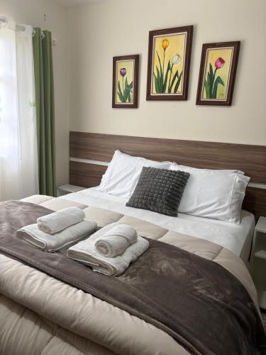a bedroom with a bed with towels on it at Casa no Roteiro do Vinho in São Roque
