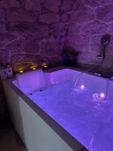 a bath tub with purple lighting in a room at Parenthèse entre forêt et château in Pierrefonds