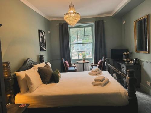 a bedroom with a large bed with two towels on it at Rock House Hotel in Lynmouth