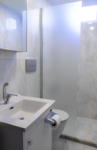 a white bathroom with a sink and a shower at Cappadocia Beyaz Konak 1 in Gülşehir