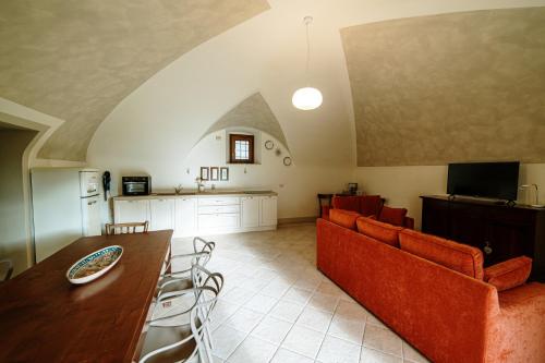 a living room with a couch and a table and chairs at La Dimora in Roe