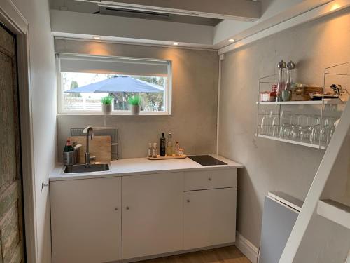 a kitchen with a sink and a window with an umbrella at Central guesthouse in Halmstad