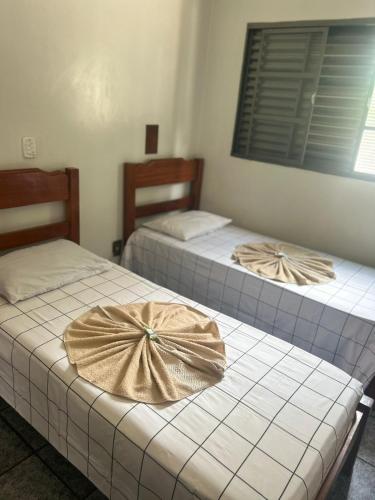 two beds with bows on them in a room at Hotel Ravena Araraquara in Araraquara