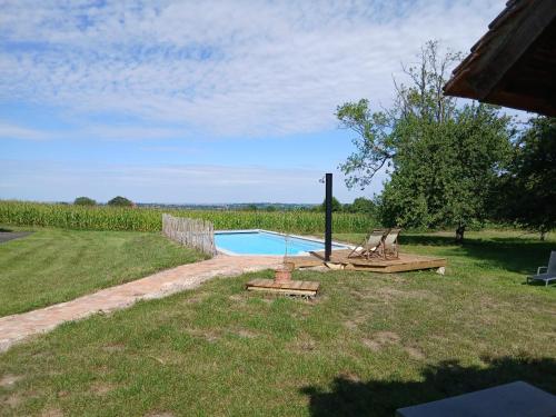 un cortile con piscina e tavolo da picnic di La Maisonnette a Saint-Pierre-sur-Dives