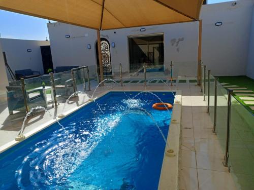 una piscina con acqua blu in un edificio di شاليه لارا a Rayyis