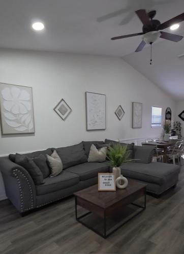 a living room with a couch and a ceiling fan at Serene Family Retreat Jax w/Pool + Firepit. in Jacksonville
