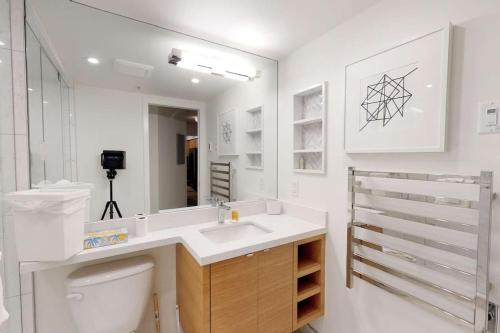 a bathroom with a sink and a toilet and a mirror at Powderhorn by Whistler Blackcomb Vacation Rentals in Whistler