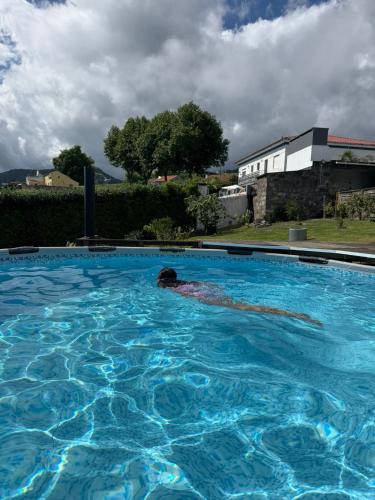 a person swimming in a large swimming pool at Quinta da Carlota in Povoação