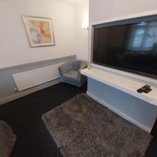 a living room with a large flat screen television at Make It Your Home in Wednesfield