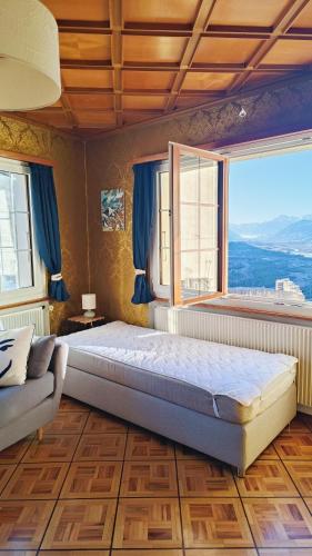 a bedroom with a large bed and a large window at Casa Jenini - Wohnung im Patrizierhaus neben Schloss Leuk in Leuk