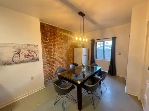 a dining room with a table and chairs and a brick wall at FULL KITCHEN 12min from DTOWN Room B in Montréal