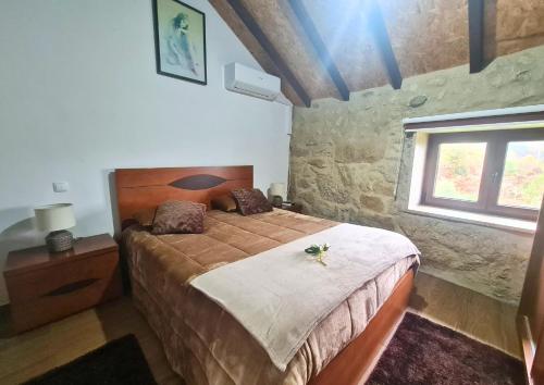 a bedroom with a large bed in a room with a window at O Palheiro in Caramulo