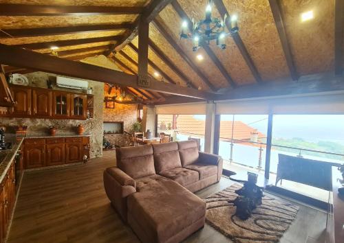 a living room with a couch and a large window at O Palheiro in Caramulo