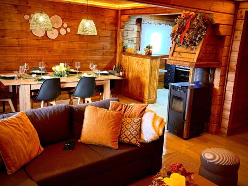 a living room with a couch and a kitchen and a table at Chalet O Refúgio 1 in Penhas da Saúde