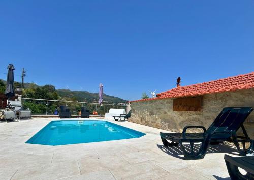 a villa with a swimming pool and two chairs at O Palheiro in Caramulo