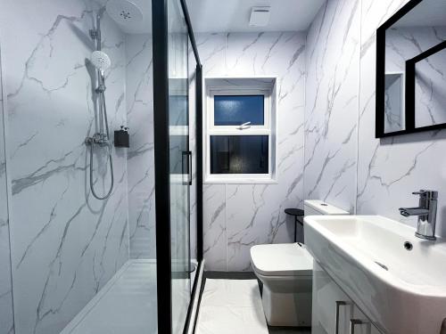 a white bathroom with a shower and a sink at Park Inn Palace in Dover