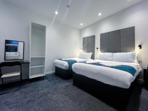 a hotel room with two beds and a flat screen tv at Park Inn Palace in Dover