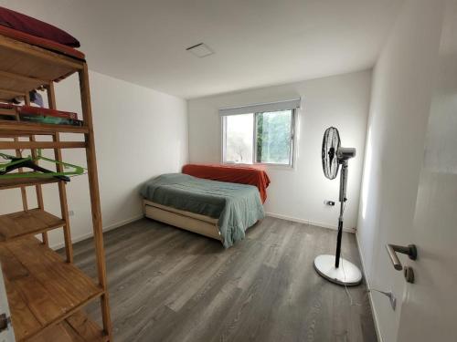 a small bedroom with a bed and a window at Quinta con pileta y quincho in Fátima