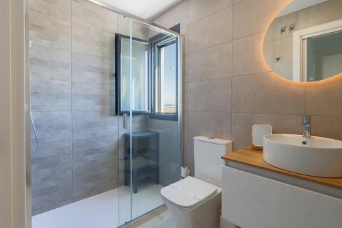 a bathroom with a toilet and a sink and a mirror at Santa Rosalìa - Casa Elsalie in Torre-Pacheco