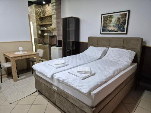 a bedroom with a bed and a dining room with a table at Niš Residence in Niš