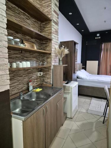 a kitchen with a sink and a bed in a room at Niš Residence in Niš