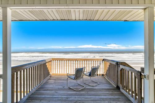 two chairs sitting on a deck with a view of the ocean at High Tide Paradise in St. Augustine