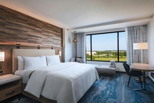 a hotel room with a bed and a desk and a window at The Westin Dallas Southlake in Southlake