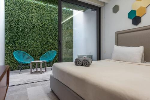 a bedroom with a bed and a green wall at Central Studio - Rooftop Pool Gym Near Beach in Playa del Carmen