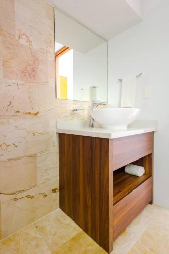 a bathroom with a sink and a mirror at Central Studio - Rooftop Pool Gym Near Beach in Playa del Carmen