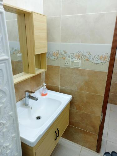 a bathroom with a sink and a shower at شاليه لارا in Rayyis