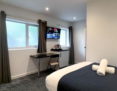 a bedroom with a bed and a desk and a window at Park Inn Palace in Dover