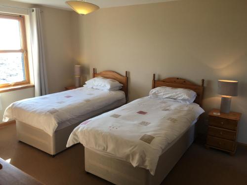 dos camas sentadas una al lado de la otra en un dormitorio en Seashore House en Johnshaven