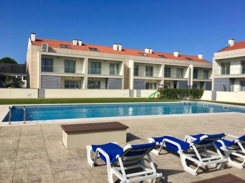 a group of lounge chairs and a swimming pool at SeaHorse House in Esposende