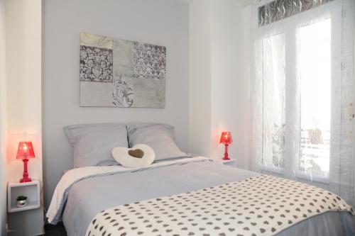 a white bedroom with a bed with a heart pillow on it at Suite Imperazur Five stars Holiday House in Nice