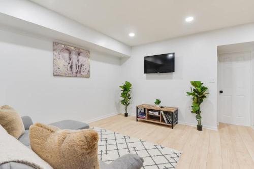a living room with a couch and a tv on a wall at Stylish 2BR Near Union Market & Metro in Washington, D.C.
