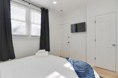 a white bedroom with a bed and a window at Stylish 2BR Near Union Market & Metro in Washington, D.C.