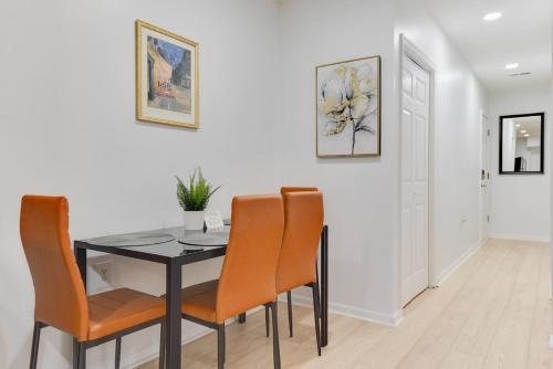 a dining room with a black table and orange chairs at Stylish 2BR Near Union Market & Metro in Washington, D.C.